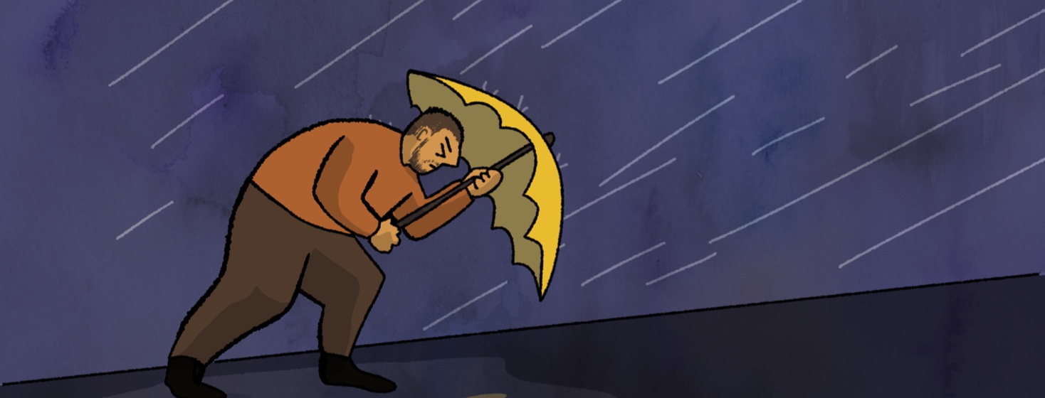 A man walking uphill in a rainstorm against the wind