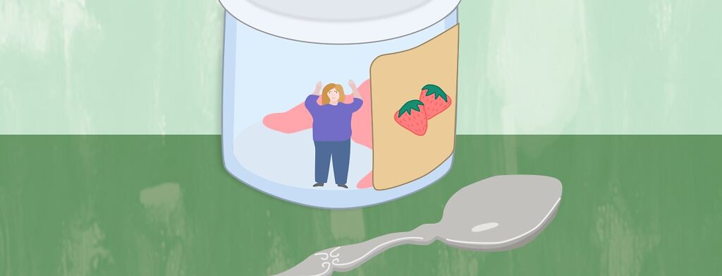 A woman is trapped in a jar of strawberry baby food with a giant spoon.